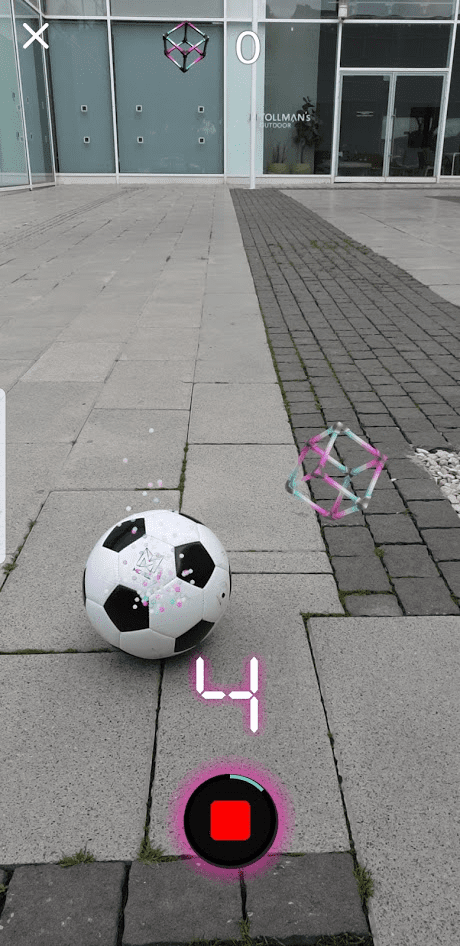 אפליקציית Zooz. התמונה מכילה כדור, קובייה צבעונית וירטואלית במציאות מדומה, ומדרכה ציבורית
