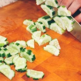 person slicing cucumber vegetable