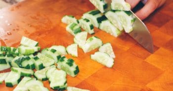 person slicing cucumber vegetable