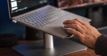 crop faceless man using laptop on stand