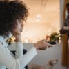 young black woman watching tv with interest near boyfriend standing in room